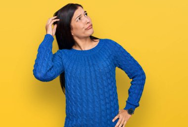 Gündelik kıyafetler giyen genç İspanyol kadın soru sorup kafasını karıştırıyor. Şüpheyle kararsız, kafa kafaya düşünerek. Düşünceli kavram. 