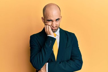 İş elbisesi ve kravat takan İspanyol genç adam kollarını kavuşturup depresyondan sıkılmış ve yorgun görünüyor.. 