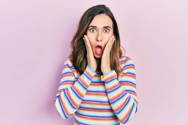 Günlük kıyafetler giyen genç İspanyol kız korkmuş ve şok olmuş, şaşırmış ve şaşırmış bir yüz ifadesi var. 