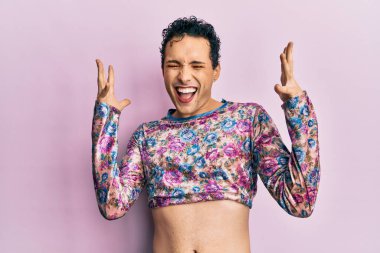 Makyaj giysileri giymiş yakışıklı bir adam, çılgın ve başarının delicesine kutlama yapıyor. Kolları havada ve gözleri kapalı, heyecanlı çığlıklar atıyor. Kazanan konsept 