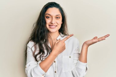 Güzel bir orta doğulu kadın gündelik kıyafetler giyip kameraya hayret ediyor ve gülümsüyor.. 