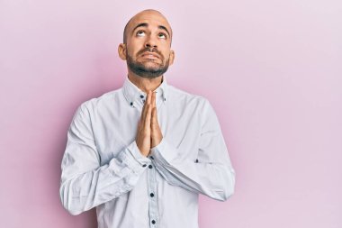 Gündelik giysiler giyen genç İspanyol adam elleri bağlı yalvarıyor ve dua ediyor. Yüzünde umut ifadesi var. Çok duygusal ve endişeli. Yalvarıyor. 