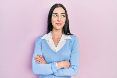 Pembe arka planda duran mavi gözlü güzel kadın gülümsüyor ve yan tarafa bakıyor ve düşünüyor.. 