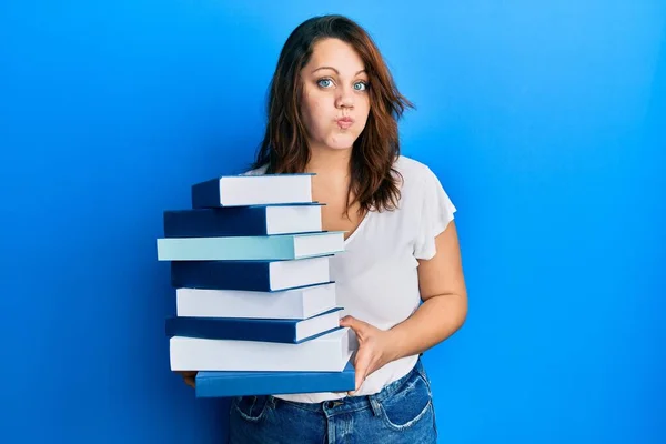 Young Caucasian Woman Holding Pile Books Puffing Cheeks Funny Face — Stock Photo, Image