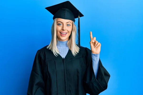 Krásná Blondýnka Sobě Maturitní Čepici Slavnostní Župan Ukazuje Ukazuje Prstem — Stock fotografie