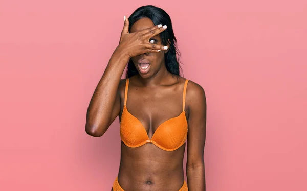 Young African American Woman Wearing Lingerie Using Tape Measure