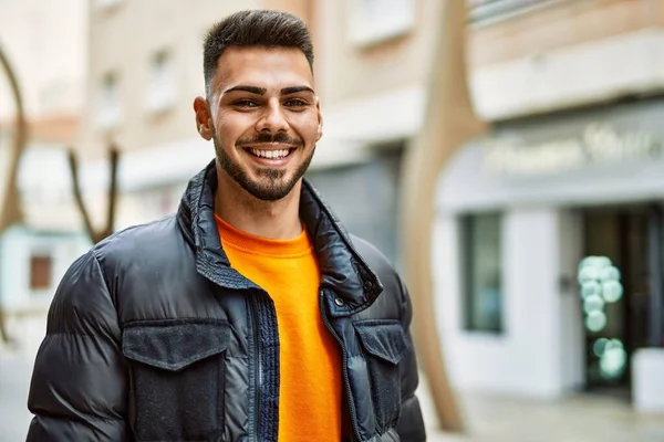 Yakışıklı, sakallı, neşeli ve kendine güvenen, kışlık palto giyen bir İspanyol.