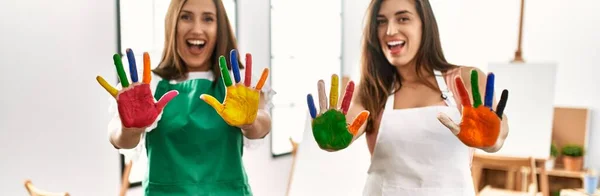 Два Латинских Студента Улыбаются Счастливо Показывая Забавные Раскрашенные Руки Художественной — стоковое фото