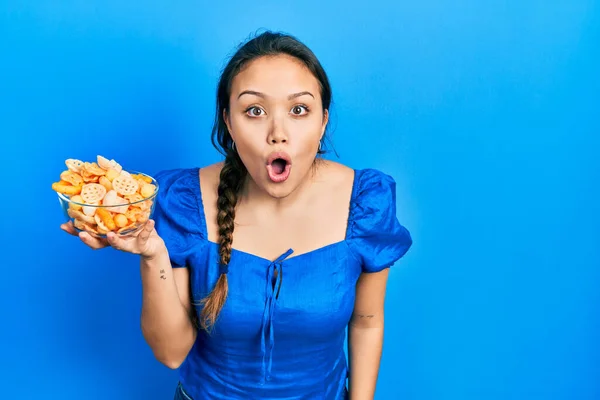 Young Hispanic Girl Holding Bowl Potato Chip Scared Amazed Open — Stock Photo, Image