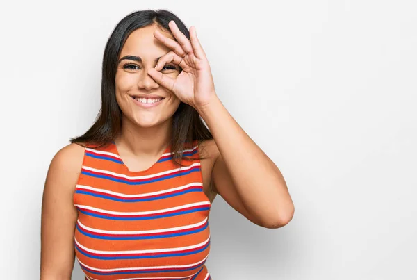 Młoda Brunetka Kobieta Luźnych Ubraniach Robi Gest Uśmiechem Dłoni Oko — Zdjęcie stockowe