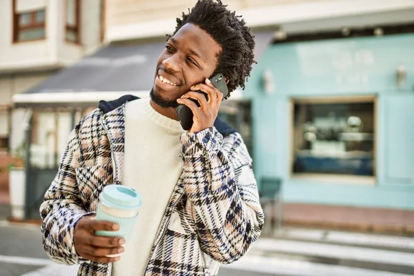 Handsome black man with afro hair having a conversation speaking on the phone