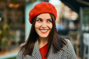 Genç İspanyol kadın gülümseyerek şehirde mutlu mesut dikiliyor..