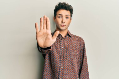 Günlük kıyafetler giyen yakışıklı İspanyol adam avucunun içi gibi şarkı söylemeyi kesiyor. Yüzünde olumsuz ve ciddi bir jest olan uyarı ifadesi. 