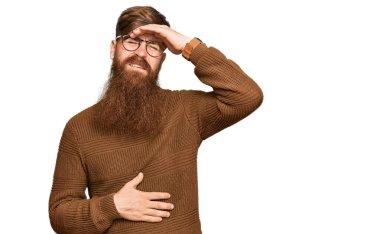 Genç İrlandalı kızıl elbiseli ve gözlüklü adam hastalık, ateş, grip ve soğuk algınlığı için alnına dokunuyor. 