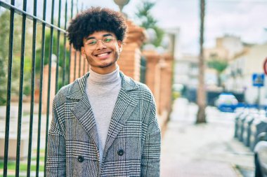 Genç Afrikalı Amerikalı iş adamı şehirde mutlu mesut dikiliyor..