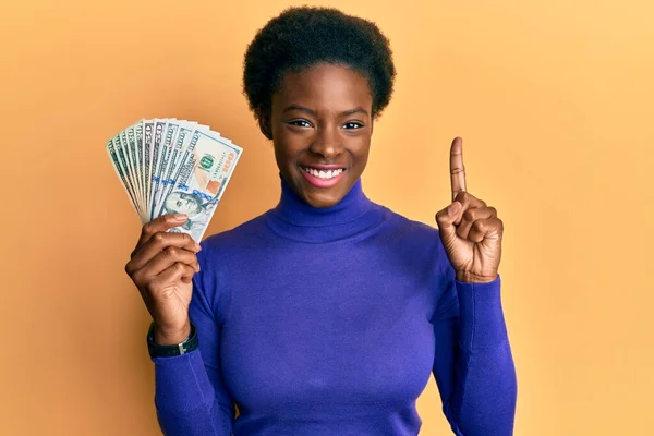 Chica Afroamericana Joven Sosteniendo Dólares Sonriendo Con Una Idea Pregunta —  Fotos de Stock