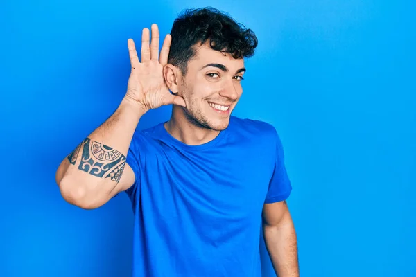 Pemuda Hispanik Mengenakan Kaos Biru Santai Tersenyum Dengan Tangan Atas — Stok Foto