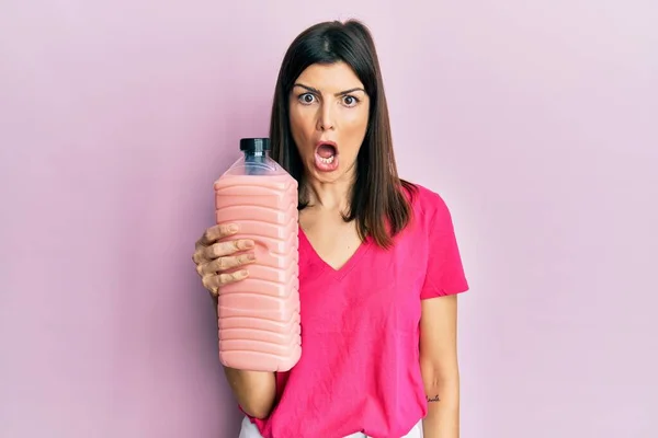 Junge Hispanische Frau Mit Weichspülerflasche Der Hand Erschrocken Und Erstaunt — Stockfoto