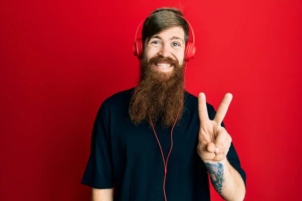 Kızıl Saçlı Uzun Sakallı Müzik Dinleyen Kulaklık Takan Iki Numaralı — Stok fotoğraf