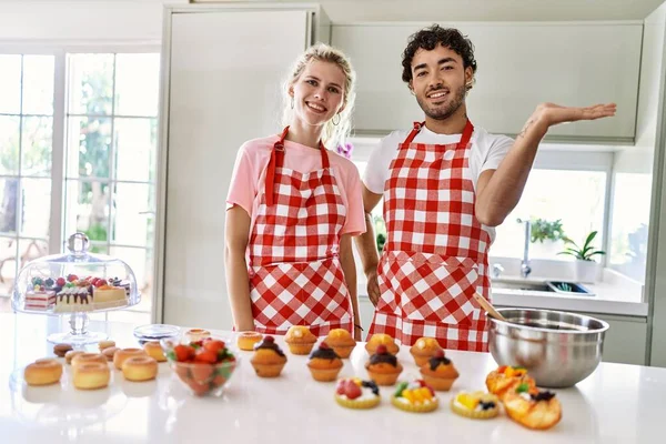 Δύο Σύζυγοι Μαγειρεύουν Γλυκά Στην Κουζίνα Χαμογελώντας Χαρούμενα Παρουσιάζοντας Και — Φωτογραφία Αρχείου