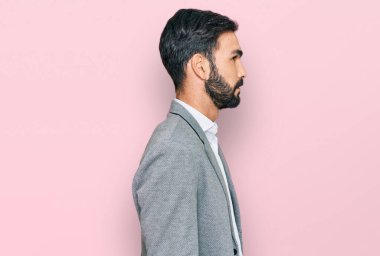 İş elbiseleri giyen genç İspanyol bir adam profilini rahatlatmak için doğal bir yüz ve kendine güvenen bir gülümseme takınıyor.. 