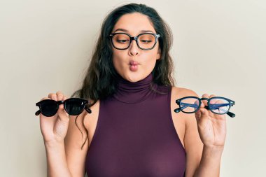 Güzel bir ortadoğulu kadın elinde farklı gözlüklerle balık suratlı ve şaşı gözlü, çılgın ve komik.. 