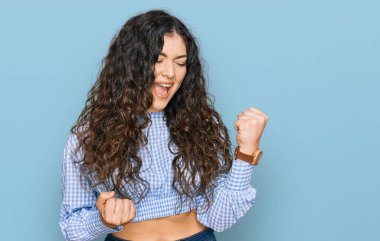 Gündelik giysiler giyen genç İspanyol kız kolları havada ve gözleri kapalı bir şekilde başarının şaşkınlığını ve şaşkınlığını yaşıyor. Kazanan konsept. 