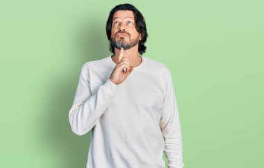 Orta yaşlı, günlük giysiler giyen, çenesinde parmak olan, şüpheye odaklanmış, kafasını kaldırıp, 