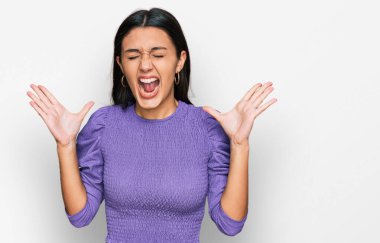 Gündelik kıyafetler giyen genç İspanyol kız başarı için deli ve çılgınlığı kutluyor kollarını kaldırmış ve gözlerini kapatmış heyecanla bağırıyor. Kazanan konsept 