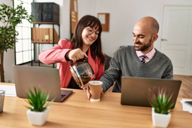 İki İspanyol iş adamı mutlu gülümsüyor. Ortağım ofiste kahve dolduruyor..