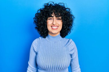 Orta Doğulu genç bir kadın mutlu ve havalı bir gülümseme takınıyor. şanslı kişi. 