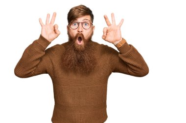 Genç İrlandalı kızıl elbiseli ve gözlüklü adam şaşırmış ve şaşırmış görünüyor. çılgın ifade 
