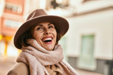 Şık giyinen genç İspanyol kadın şehirde dikiliyor..