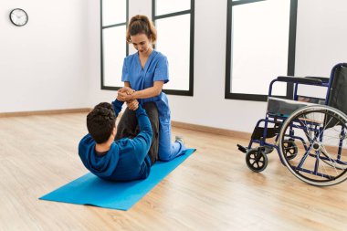 Klinikte hareket kabiliyeti egzersizi yapan genç bir adam..