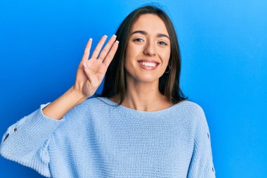 Latin kökenli genç bir kız günlük kıyafetler giyer ve parmaklarıyla dört numarayı gösterir.. 