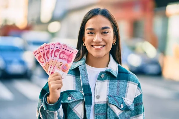 Young Latin Girl Smiling Happy Holding Chinese Yuan Banknotes City — Stock Photo, Image