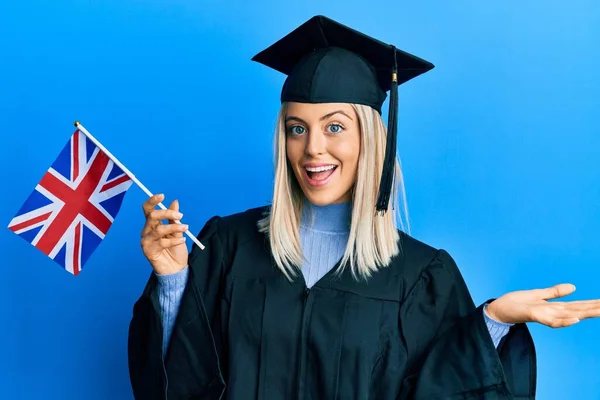 Hermosa Mujer Rubia Con Gorra Graduación Bata Ceremonia Sosteniendo Bandera —  Fotos de Stock