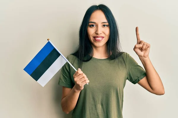 Menina Hispânica Jovem Segurando Bandeira Estonia Sorrindo Com Uma Ideia — Fotografia de Stock