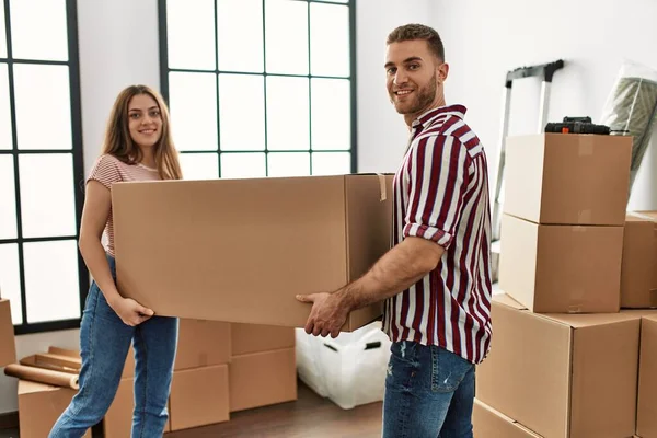 Jovem Casal Caucasiano Sorrindo Feliz Segurando Caixa Papelão Nova Casa — Fotografia de Stock