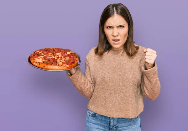 Joven Mujer Hermosa Sosteniendo Pizza Italiana Molesto Frustrado Gritando Con —  Fotos de Stock