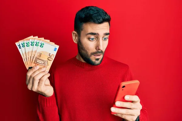 Fiatal Spanyol Férfi Használ Okostelefon Gazdaság Euró Bankjegyek Sokk Arc — Stock Fotó