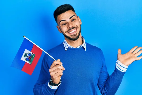 Ung Latinamerikansk Man Med Skägg Håller Haiti Flagga Firar Prestation — Stockfoto