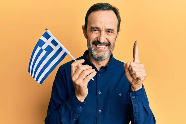 Homem Hispânico Meia Idade Segurando Bandeira Grécia Sorrindo Com Uma — Fotografia de Stock