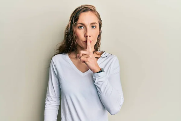 唇に指で静かにするように頼むカジュアルな服を着た若いブロンドの女性 沈黙と秘密の概念 — ストック写真