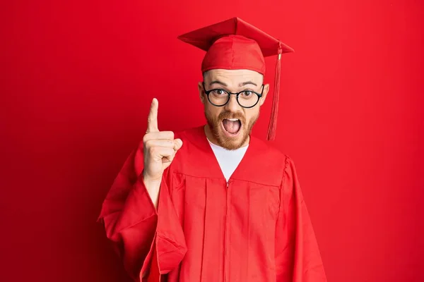 Joven Pelirrojo Vestido Con Gorra Graduación Roja Bata Ceremonia Señalando —  Fotos de Stock