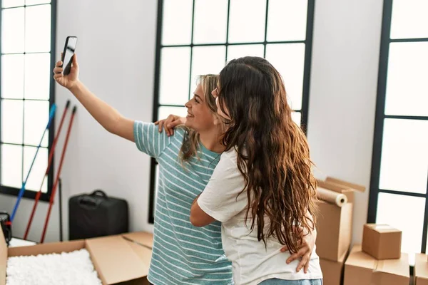 若いカップル笑顔幸せ作る自画撮りスマートフォンによって新しい家 — ストック写真
