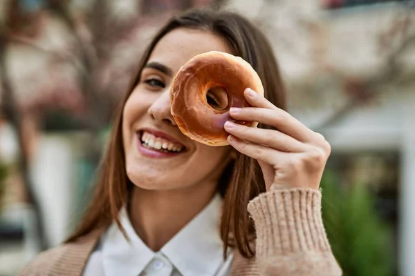 Joven Empresaria Hispana Sonriendo Feliz Sosteniendo Donut Sobre Ojo Ciudad —  Fotos de Stock