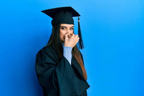 Hermosa Morena Joven Con Gorra Graduación Bata Ceremonia Oliendo Algo —  Fotos de Stock