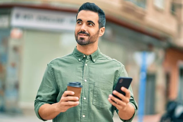 Ung Latinamerikansk Man Ler Glad Med Smartphone Stan — Stockfoto