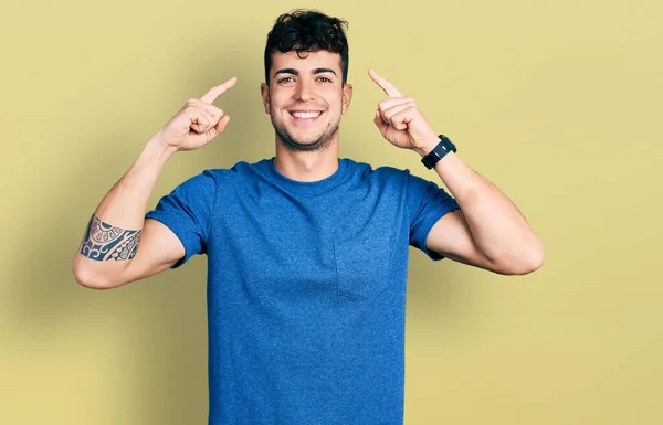 Gündelik Tişört Giyen Genç Spanyol Adam Iki Eliyle Başını Işaret — Stok fotoğraf